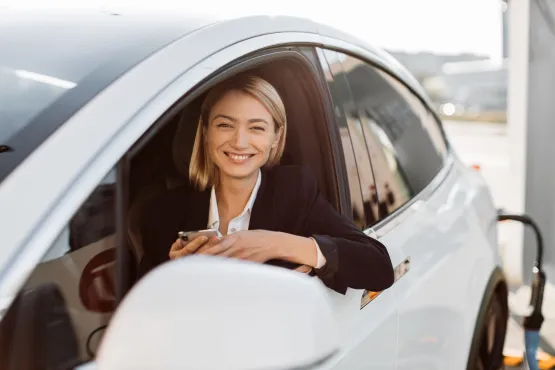 femme taxi elancourt rechargeant voiture electrique sur borne tesla